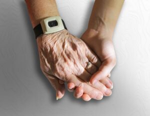Un caregiver stringe la mano di un malato di SLA